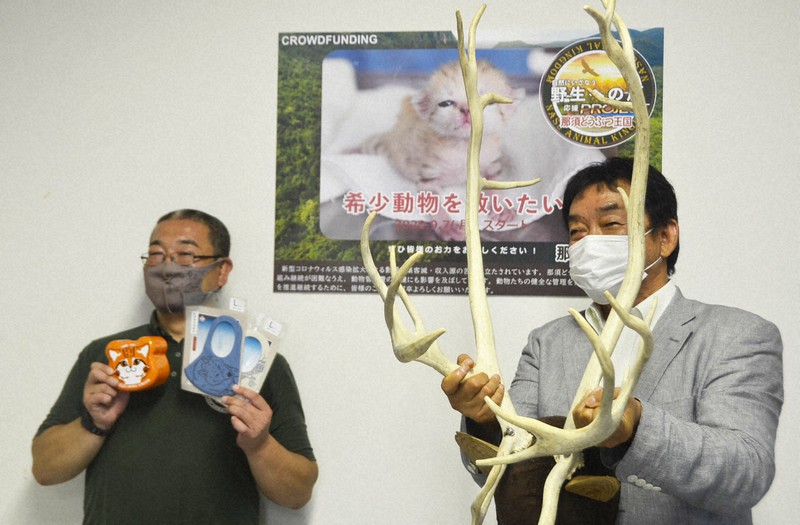 返礼品のトナカイの角やマスクなどのグッズを持って寄付を呼びかける佐藤哲也園長(右)ら=栃木県那須町の那須どうぶつ王国で2020年9月7日午前11時45分、湯浅聖一撮影