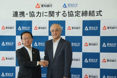 協定締結式で握手する、伊藤行記・取締役頭取（左）と川井伸一学長
