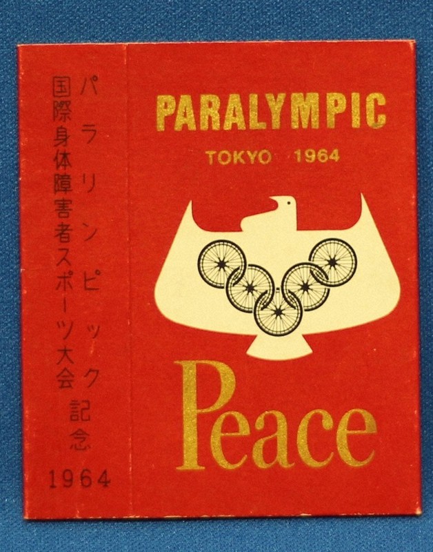 1964年東京パラリンピックのロゴ。車椅子の輪が人生を克服する勝利のV字を描き、世界を結ぶ=中京大スポーツミュージアム蔵