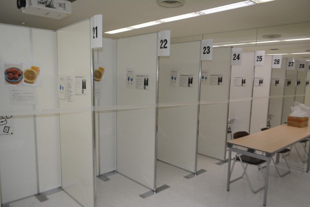 検疫検査場の特設ブース。新型コロナの検査に使う唾液を出しやすいよう、梅干しやレモンの写真が張られている。行われるのはPCRではなく抗原検査だ=成田空港で2020年8月17日午前11時50分、中村宰和撮影
