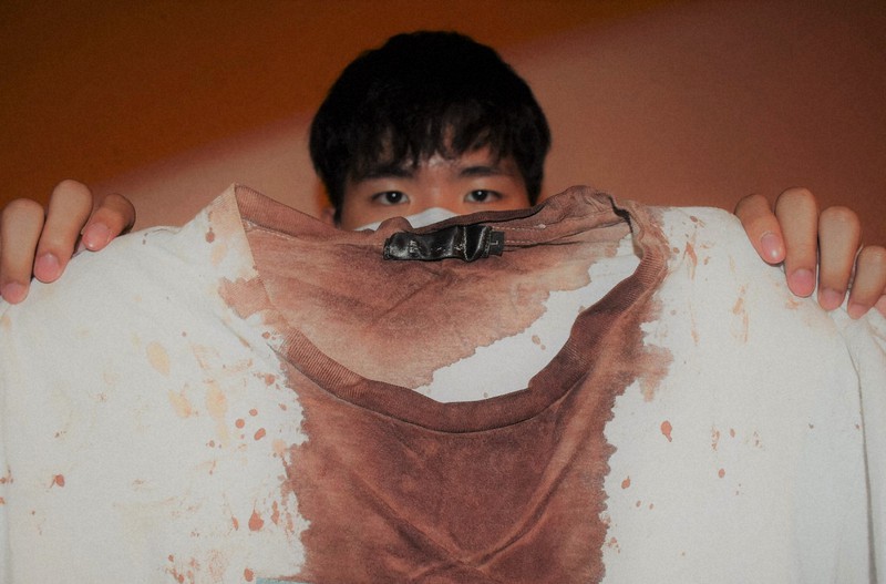 血で染まったTシャツを手にする李さん=香港で2020年9月3日、福岡静哉撮影