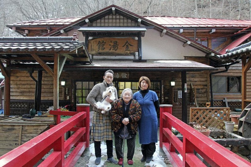 宿を切り盛りする4代目の佐藤淳さん、知美さん夫妻と3代目女将のみどりさん、そして愛犬のリッチ