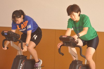 フィットネスバイクで心肺機能を高める清水彩花（左）と田畑真紀監督。静寂の中で緊迫した時間が流れる＝北海道苫小牧市の駒大苫小牧高で2020年9月9日午後3時37分、岩壁峻撮影
