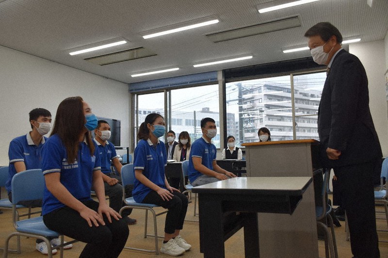 「盛岡情報ビジネス&デザイン専門学校」の工藤昌雄校長のあいさつに笑顔を見せる実習生=盛岡市大沢川原で