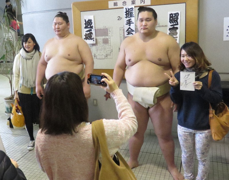 握手会でファンとの記念撮影に応じる照ノ富士(右から2人目)と逸ノ城(同3人目)。ファンとの距離の近さも巡業の魅力だ=千葉県市川市の塩浜市民体育館で2015年4月11日午前8時52分、村社拓信撮影