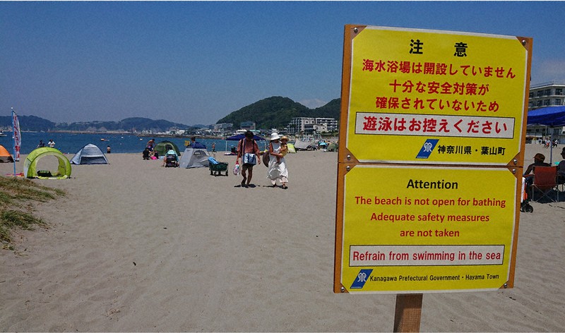 夏真っ盛りの8月中旬、神奈川県葉山町の森戸海岸には海水浴場が開かれていないことを知らせる看板が立っていた=岩崎信道撮影