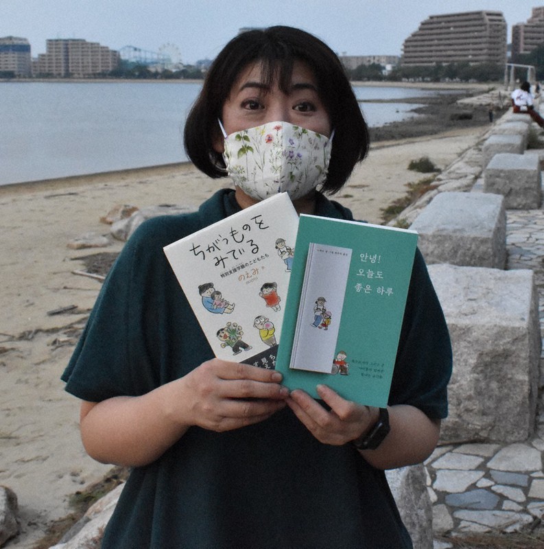 「ちがうものをみている」の日本語版と韓国語版を手にするのえみさん