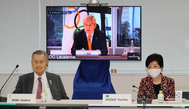 リモート参加であいさつするトーマス・バッハIOC会長(奥)と、出席した東京五輪・パラリンピック組織委員会の森喜朗会長(左)、小池百合子東京都知事=東京都中央区で2020年9月24日午後4時50分、代表撮影