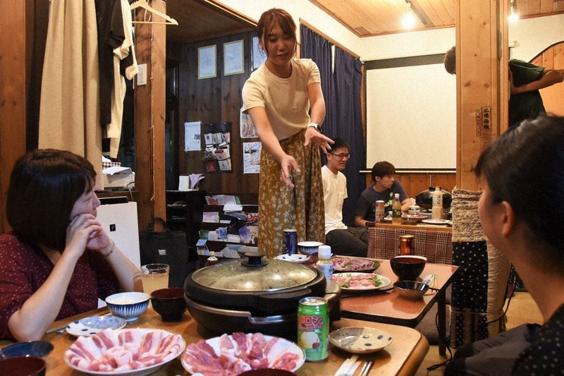 テーブルに並んだ鹿児島産のヒラマサや黒豚の説明をする郡司紗希さん(中央)=宮城県気仙沼市階上で、神内亜実撮影