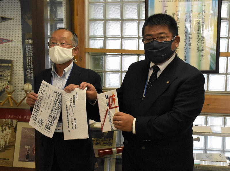 第2次支援金の目録を渡された西條浩章会長(右)と、球児からの「お礼のメッセージ集」を渡された池口良明会長=長野県上田市の県営上田野球場で2020年9月26日、皆川真仁撮影