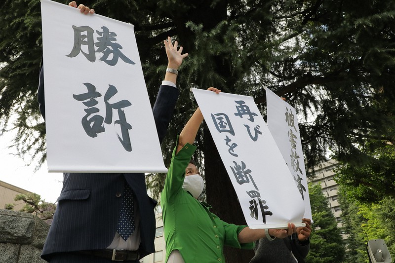 福島原発集団訴訟の判決後、「勝訴」などと書かれた紙を掲げる原告団ら=仙台高裁前で2020年9月30日午後2時34分、和田大典撮影