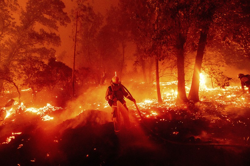 山火事の消火活動を行う消防士。専門家は、気候変動が米西部の山火事の規模や被害を拡大させていると指摘する=米カリフォルニア州で9月7日、AP