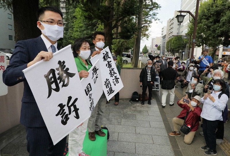 福島第1原発事故の集団訴訟判決後、「勝訴」などと書かれた垂れ幕を掲げる原告弁護団=仙台高裁前で30日、和田大典撮影