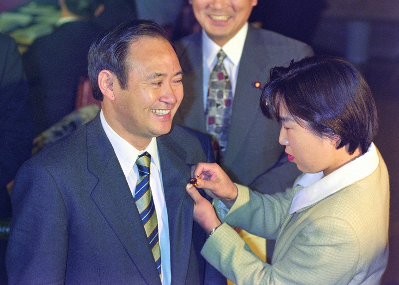 衆院選初当選後の1996年11月の特別国会召集日に初登院して職員に議員バッジをつけてもらう自民党の菅義偉氏=国会内で1996年11月7日撮影