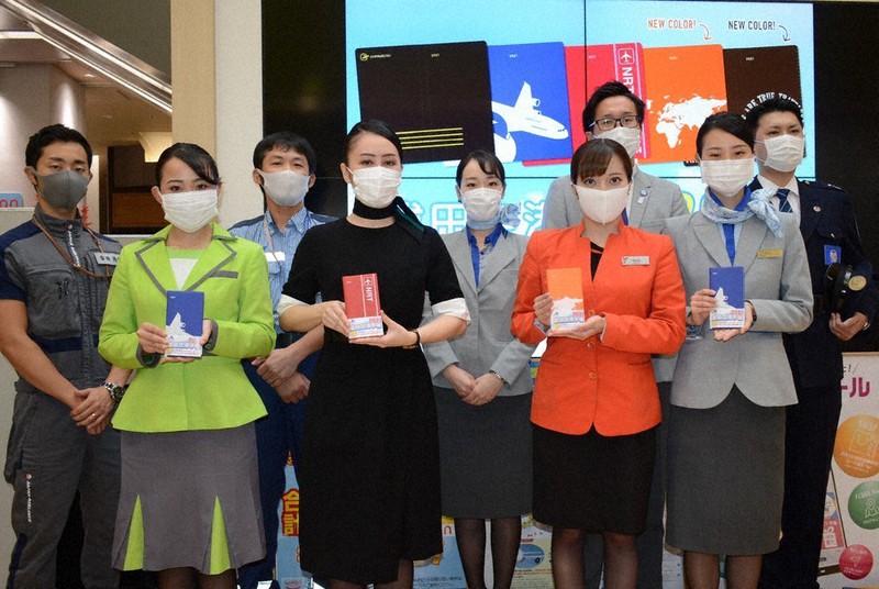制服を着て空港手帳をPRする航空各社の客室乗務員や地上旅客係員ら=千葉県成田市で