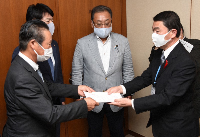 女川原発の早期再稼働と避難道路整備を求める意見書を村井嘉浩知事(右)に手渡す石巻市議会の大森秀一議長(左)=宮城県庁で2020年10月2日、百武信幸撮影