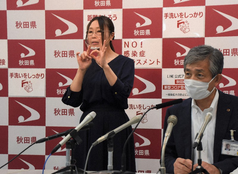 新型コロナウイルスの感染者に関する秋田県の会見で手話通訳をする歩仁内ゆかりさん(左)=秋田県庁で、川口峻撮影