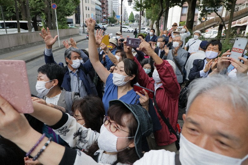 東京電力福島第1原発事故を巡る集団訴訟訴訟で、「勝訴」と書かれた垂れ幕を見て喜ぶ原告の人たち=仙台市青葉区の仙台高裁前で9月、和田大典撮影
