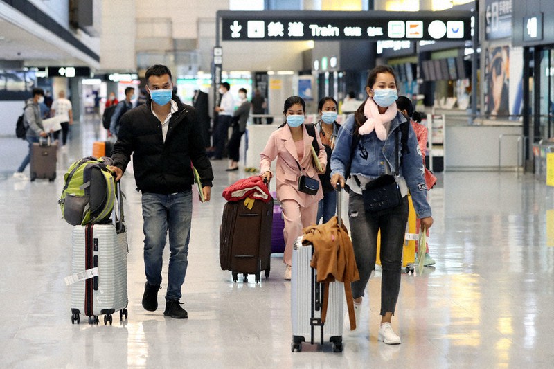 入国し、スーツケースを手に迎えの車に向かうカンボジア人ら=成田空港で2020年10月1日、小川昌宏撮影