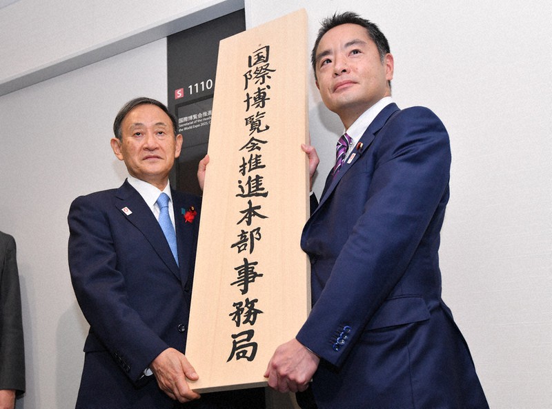 国際博覧会推進本部事務局の看板掛けをする菅首相(左)と井上万博担当相=宮間俊樹撮影