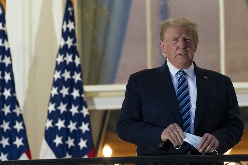 ホワイトハウスに戻り、バルコニーでマスクを外したトランプ大統領=ワシントンで2020年10月5日、AP