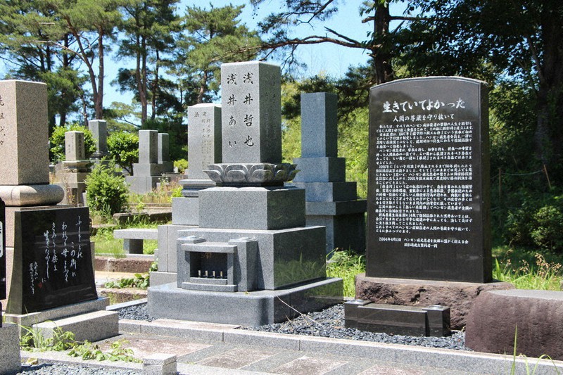 「生きていてよかった」との顕彰碑の横にある浅井あい氏の墓石=金沢市の奥卯辰山墓地公園で、宍戸護撮影