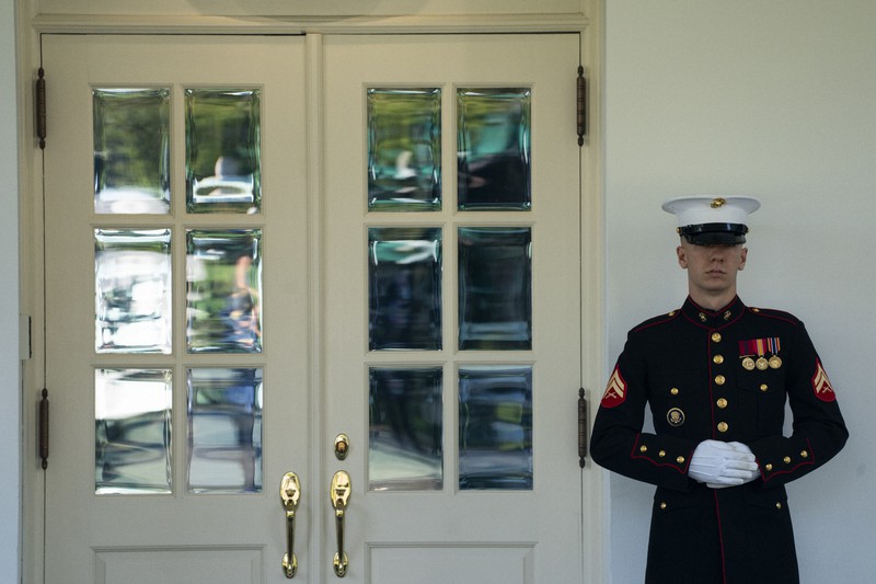 トランプ米大統領が執務室入りしたホワイトハウスで警備に当たる海兵隊の兵士=2020年10月7日、AP