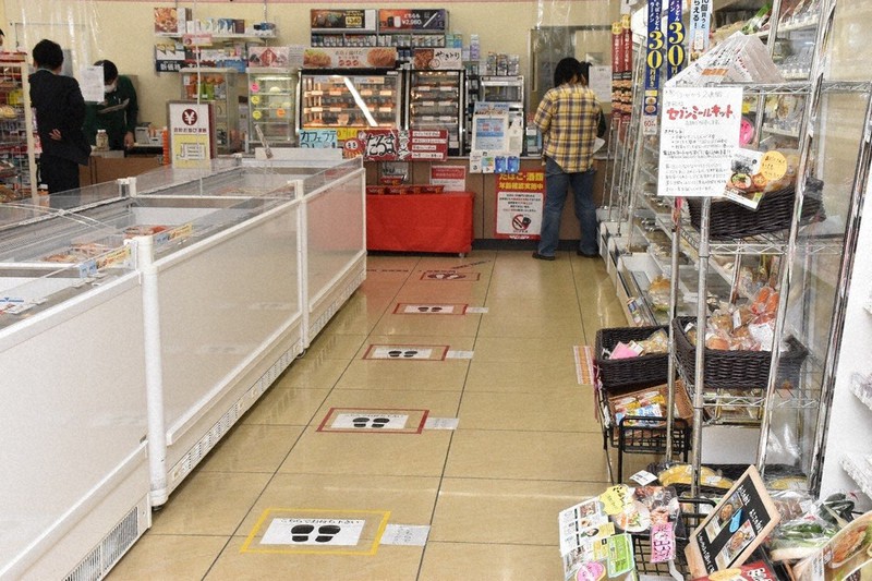 新型コロナウイルスの感染拡大を受け、1メートル間隔でレジ待ちの目印を床に貼ったセブン-イレブンの店舗=大津市で2020年4月17日、菅健吾撮影