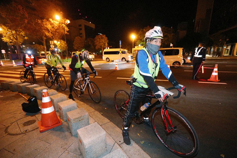 東京オリンピックのマラソンコースを自転車に乗って計測する世界陸連の関係者ら=札幌市中央区で2020年10月10日午前1時56分(代表撮影)