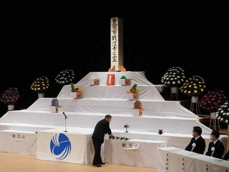 兵庫県豊岡市戦没者追悼式で献花する森田健治・市遺族会長(中央)=同市立野町の豊岡市民会館で、村瀬達男撮影