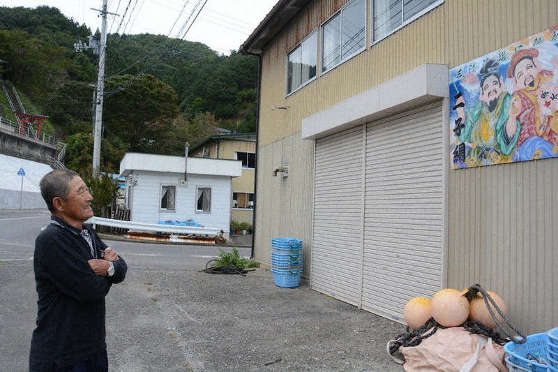 修復された番屋を笑顔で見上げる熊谷実さん。仲間と集った思い出の場所だ=岩手県普代村で10月1日、安藤いく子撮影