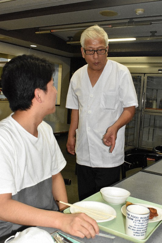 料理を作った後に学生と話し込む寮長の川上ひろしさん(右)=東京都調布市の開成調布学生会館で9月25日