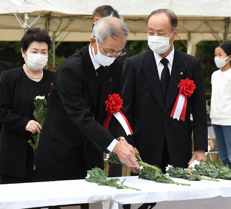 原爆慰霊碑を前に献花する参列者たち=松江市学園南1の北公園で、目野創撮影