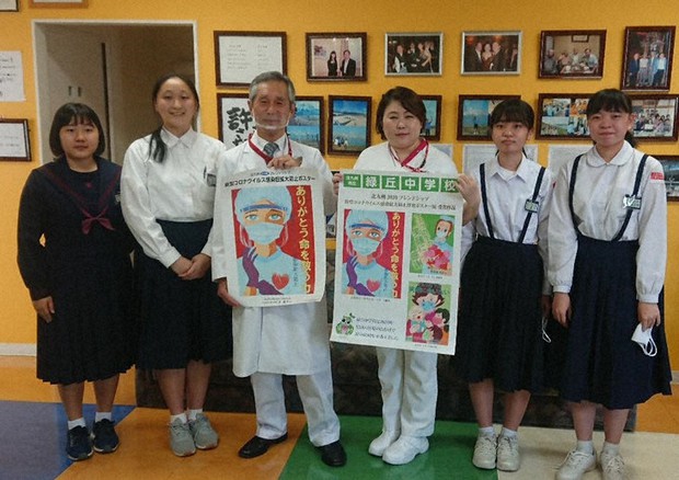 甲斐院長(中央左)、成瀬看護部長(同右)にポスターを贈った緑丘中の生徒たち。院長が手にするのが最優秀の今さんの作品。励ましの気持ちを込めて明るい色で描いたという