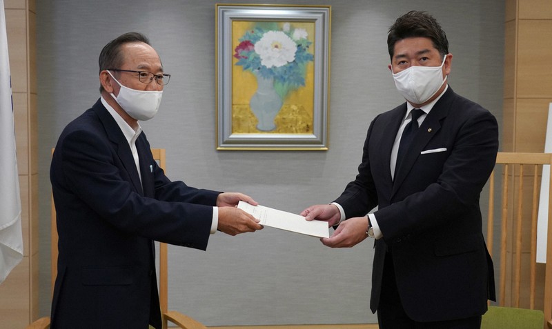 川崎市のヘイトスピーチ禁止条例に基づき、ヘイトスピーチと認定したツイート2件の削除要請などを求める答申を福田紀彦市長(右)に提出する「川崎市差別防止対策等審査会」会長の吉戒修一弁護士=川崎市役所で2020年10月16日、後藤由耶撮影