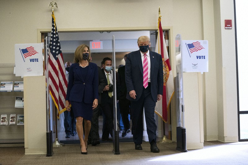 米南部フロリダ州ウエストパームビーチの期日前投票所を訪れて投票を済ませたトランプ大統領(右)=2020年10月24日撮影、AP