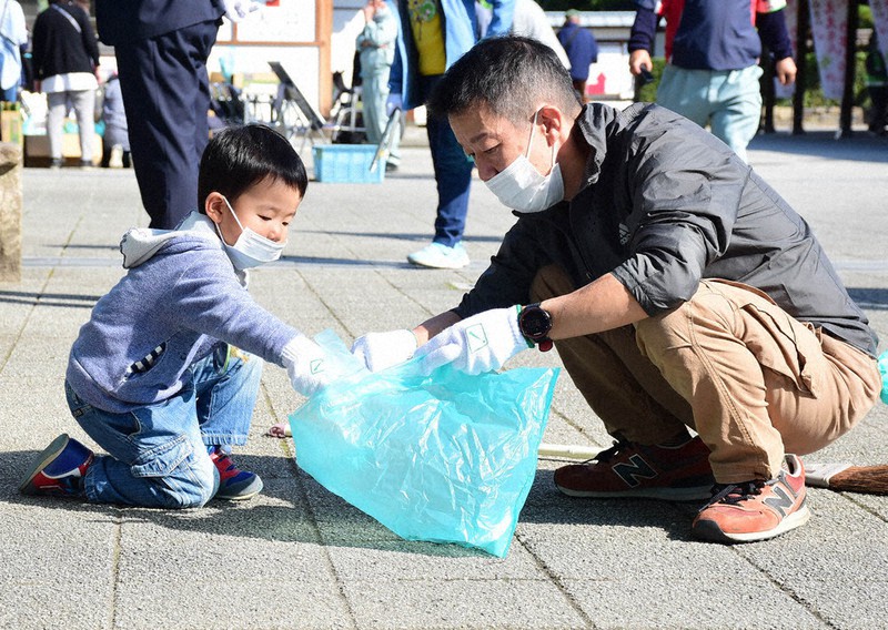 ゴミを拾い集める参加者たち=高松市の栗林公園で、潟見雄大撮影