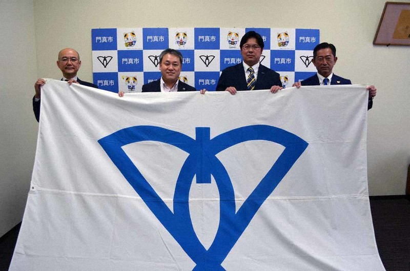 宮本一孝市長(左から2人目)から門真市旗を受け取った田中篤史監督(同3人目)ら=大阪府門真市役所で、亀田早苗撮影
