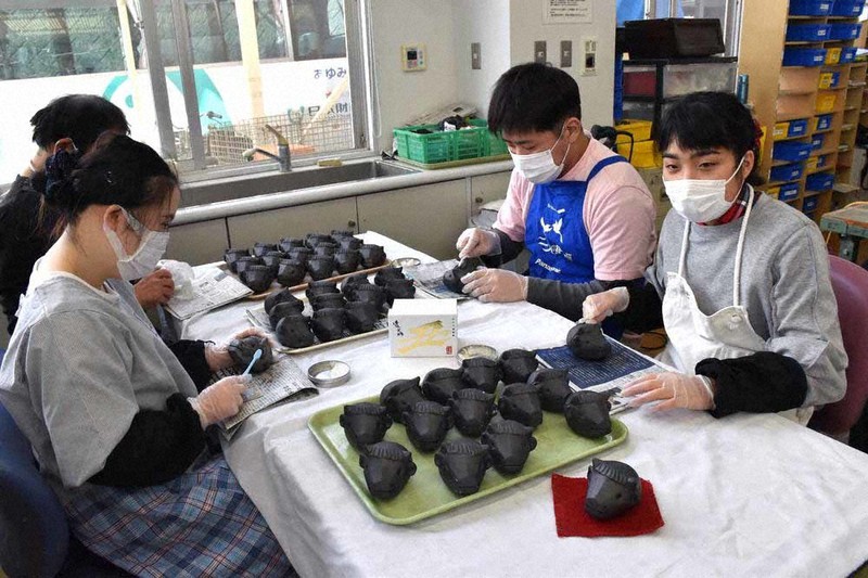 丑にちなんだ置物を磨き上げるあゆみ園の利用者ら=高松市勅使町で、川原聖史撮影