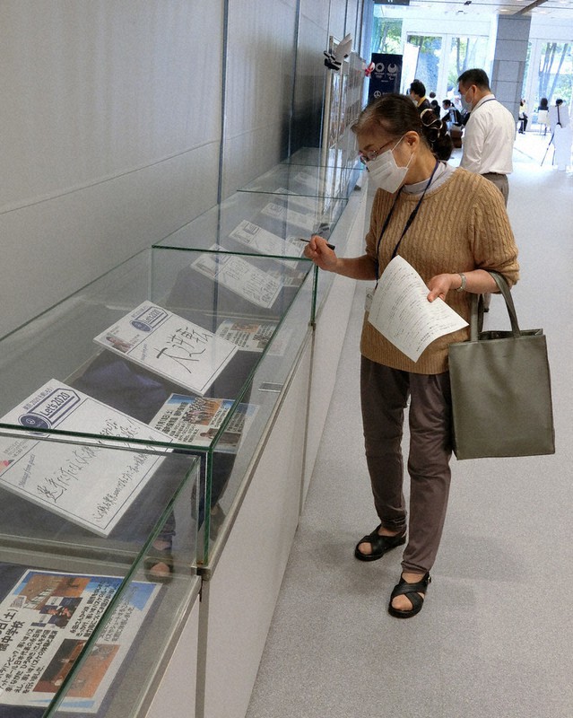 企画展「もう一度、東京2020へ」の展示品を見入る来場者=千代田区役所で