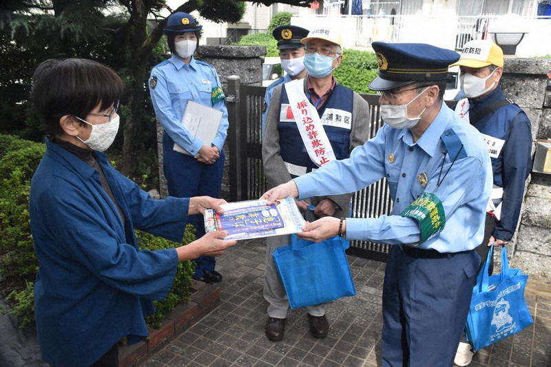 住宅を訪れ、特殊詐欺被害防止の啓発品を渡す新井文夫・浦和署長(右手前)=さいたま市浦和区で2020年10月20日、平本絢子撮影