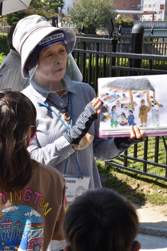 母の被爆体験を描いた紙芝居を手に、子どもたちにガイドをする大内正子さん=広島市中区で、小山美砂撮影