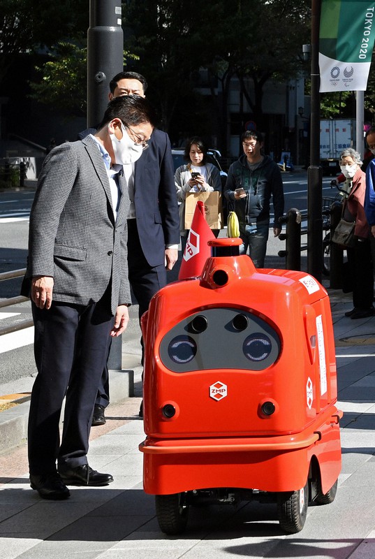 自動配送ロボットの歩道走行の実証実験を視察する加藤勝信官房長官(左)=東京都千代田区で2020年10月31日午前11時、竹内紀臣撮影