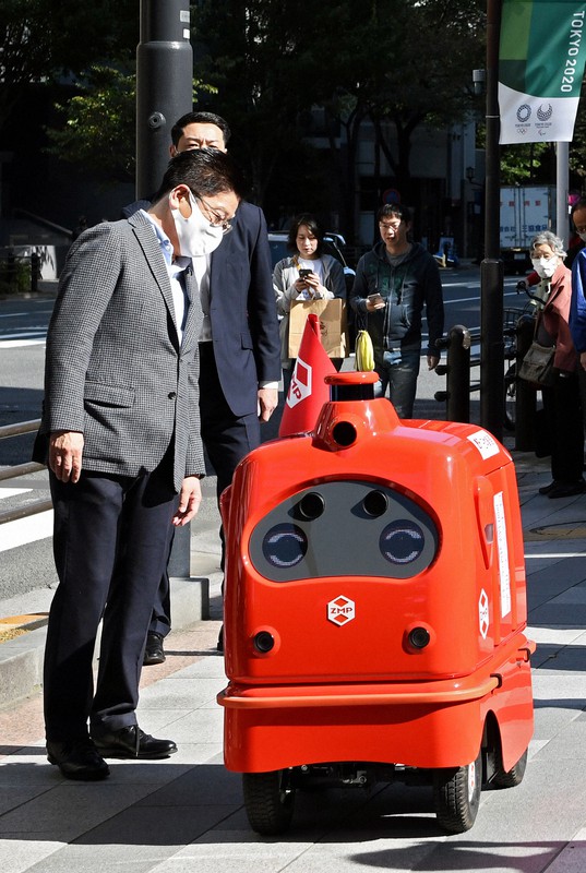 自動配送ロボットの歩道走行の実証実験を視察する加藤勝信官房長官（左）＝東京都千代田区で2020年10月31日午前11時、竹内紀臣撮影