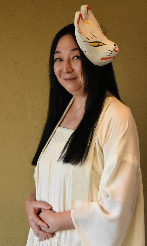 怪談を語る際にはキツネの面と白い衣装をまとう神原リカさん=境港市で、野原寛史撮影