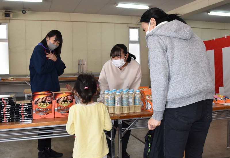 物資を受け取り、ボランティアの高校生2人(奥)と交流する家族ら=高松市で2020年10月25日午前11時43分、西本紗保美撮影