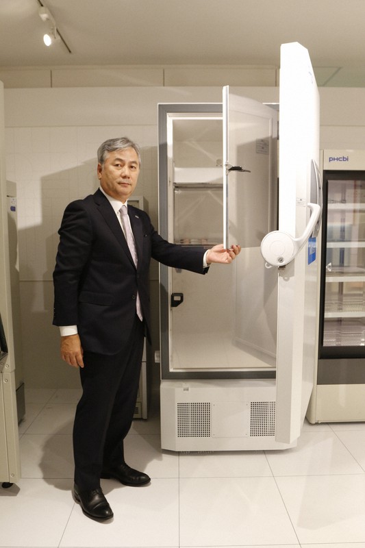 新型コロナウイルスのワクチン実用化に向け需要が急増している超低温冷凍庫。PHCホールディングス執行役員の中村伸朗氏は「この製品で5ミリリットルバイアル入りワクチン2万2000本が保管可能」と言う=東京都港区のPHC本社で2020年10月16日、横田愛撮影