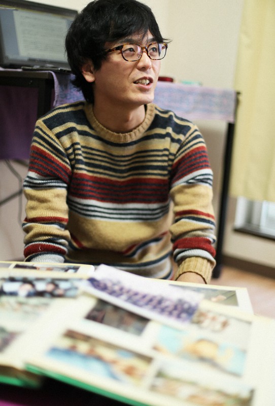 幼少期のアルバムを見て母をケアしていた当時を振り返る元ヤングケアラーの坂本拓さん=横浜市戸塚区で2020年3月21日、玉城達郎撮影