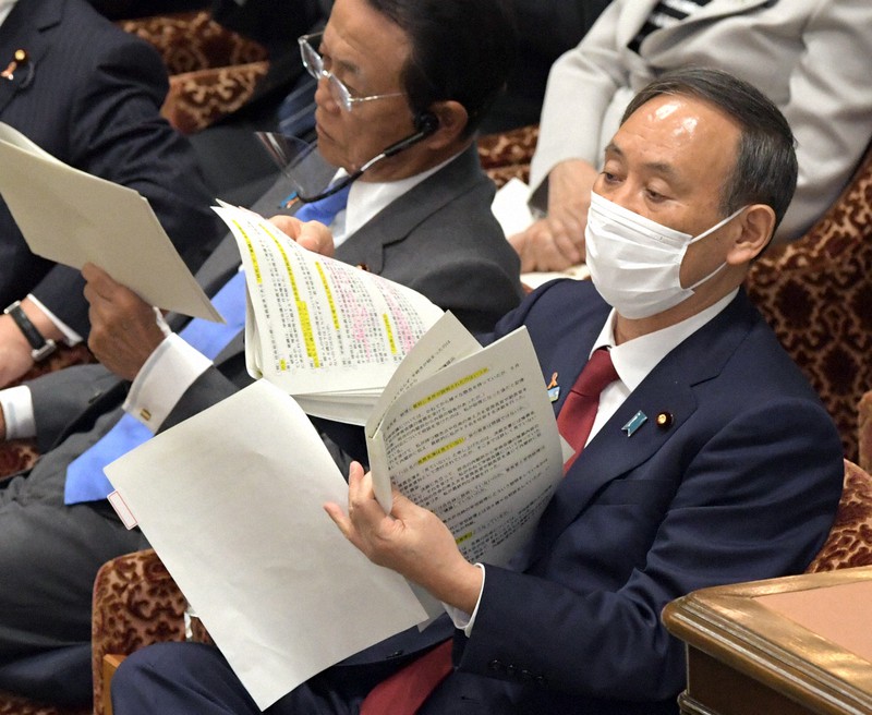 衆院予算委員会で立憲民主党の辻元清美氏の質問に答えるため資料を見る菅義偉首相(右)=国会内で2020年11月4日午後2時14分、竹内幹撮影