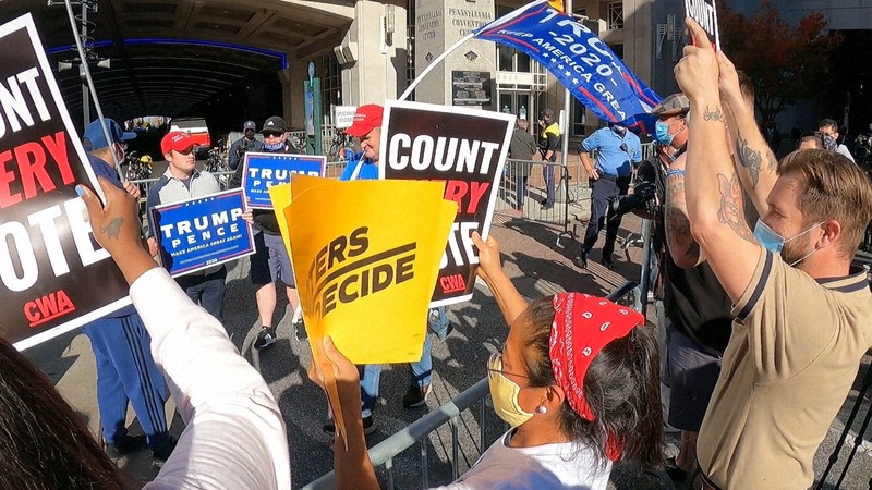 トランプ大統領の支持者(左奥)に向かって「すべての票を数えよ」などと叫ぶ市民ら=米東部ペンシルベニア州フィラデルフィアで2020年11月5日、隅俊之撮影